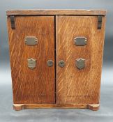 A Victorian oak humidor or smoker's cabinet with two doors with applied brass shields and