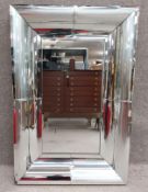 A large contemporary Art Deco style mirror with a heavy convex cushion style mirrored frame of