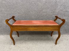 An early 20th century mahogany duet piano stool/window seat with turned and scrolling side rails