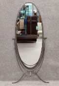 An unusual mid-century oval shaped hammered and wrought steel cheval style mirror. H.150 W.74cm. (