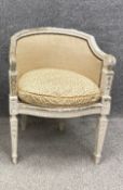 A Louis XVI style painted and upholstered tub chair with a curved back leading down to scrolling