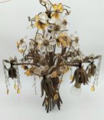 An early 20th century six branch brass chandelier of bouquet form with applied cut crystal drops and