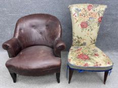 A mid-century leather low button back chair with scrolling arms raised on square tapering