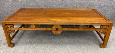 A Chinese hardwood daybed with a carved openwork apron decorated with a scrolling design, with a