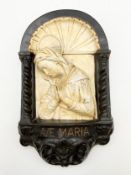 An Italian 20th century painted chalkware plaque in relief depicting the Madonna in an arched