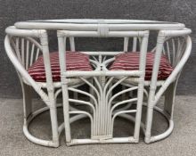 A mid to late 20th century white painted bistro set with bamboo and wicker table and chairs for