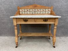 A late 19th century pitch pine wash stand with a raised and shaped gallery back inset with Art