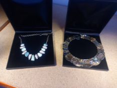 A silver necklace inset with turquoise and baroque pearls, along with a mother of pearl necklace.