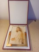 A boxed, polished chrome and gilt frame with royal crestr with a signed portrait. Frame 27.5x27.5cm