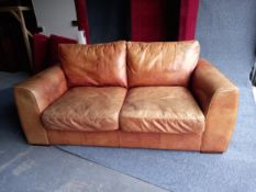 A tan leather two seater sofa. L.178cm D.95cm