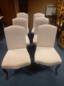 A set of six contemporary dining chairs upholstered in calico with piped edges, on carved cabriole
