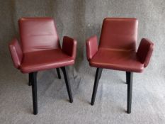 A pair of contemporary Ligne Roset red leather and ebonised beech Vik armchairs wih maker's labels.