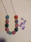 A beaded necklace along with seven loose semi-precious cut stones.
