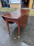 A Cuban mahogany Georgian gateleg dining table with a shaped frieze on straight tabering supports