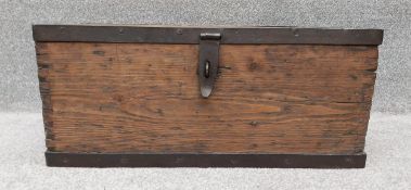 A vintage distressed pine trunk/chest with iron strap-work to the lid and base, with heavy