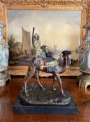 A COLD PAINTED BRONZE MODEL OF AN ARAB RIDING A CAMEL AFTER A. LEONARD