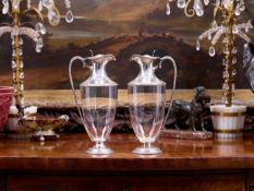 A PAIR OF LATE 19TH CENTURY STERLING SILVER MOUNTED GLASS CLARET JUGS, C. 1894