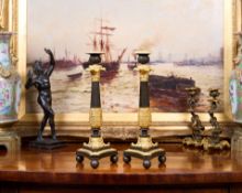 A PAIR OF EMPIRE PERIOD GILT AND PATINATED BRONZE CANDLESTICKS
