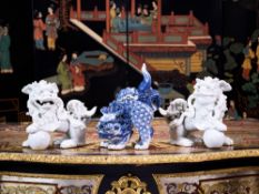 A CHINESE PORCELAIN MODEL OF A LION TOGETHER WITH A FURTHER PAIR