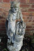 A CONCRETE WATER FEATURE OF A LADY FILLING A WATER JUG