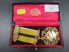 A HALLMARKED DECORATIVE SILVER GILT JEWEL WITH RIBBON