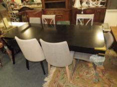 A LARGE BLACK DINING TABLE WITH AN ASSORTMENT OF EIGHT CHAIRS
