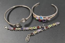 A SELECTION OF SILVER AND WHITE METAL GEM SET BANGLES AND BRACELETS