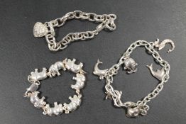 A 925 SILVER BRACELET IN THE FORM OF A ELEPHANT TRAIN TOGETHER WITH A 925 SILVER HEART AND A CHARM