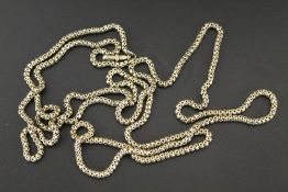 A VICTORIAN YELLOW METAL MUFF/LONG CHAIN