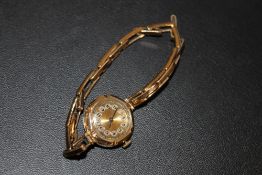 A HALLMARKED 9CT GOLD CASED WRIST WATCH ON EXPANDABLE GOLD PLATED BRACELET