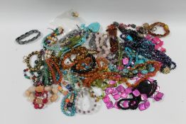 A BAG OF ASSORTED COSTUME JEWELLERY, TO INCLUDE NECKLACES , BRACELETS ETC