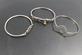 A HALLMARKED SILVER TENSION SPRING BANGLE PLUS TWO OTHERS