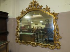A LARGE GILT WALL MIRROR 115 X 122 CM