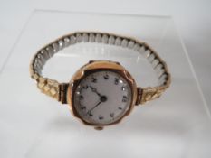 A HALLMARKED 9 CARAT GOLD WRIST WATCH ON EXPANDABLE STEEL BRACELET