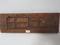 A VINTAGE CARVED WOOD PANEL DEPICTING A STEAM ENGINE AND CARRIAGES EMERGING FROM A TUNNEL