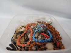 PLASTIC CONTAINER FULL OF JEWELLERY ITEMS TO INCLUDE AMBER STYLE BEADS, PEARLS ETC