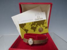 AN OMEGA 9CT GOLD LADIES MANUAL WIND WRISTWATCH, with integral mesh strap, champagne dial with baton