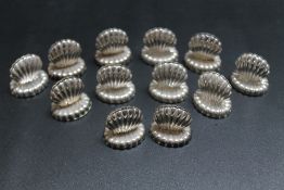 A NOVELTY SET OF TWELVE SILVER PLATED MENU HOLDERS IN THE FORM OF CLAM SHELLS, H 3 cm