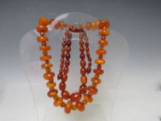 AN UNUSUAL VINTAGE AMBER BEAD NECKLACE, the chunky disc shaped amber bead interspersed with small