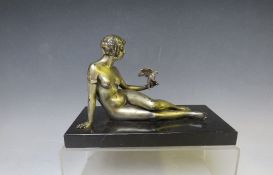 A 20TH CENTURY ART DECO STUDY OF A SILVERED METAL FEMALE NUDE HOLDING A BIRD, raised on a slate