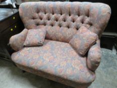 A SMALL TWO SEATER UPHOLSTERED SETTEE