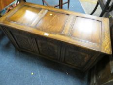 AN OAK CARVED PANELLED COFFER W 105 CM