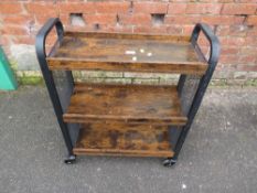 A THREE TIER BOOK TROUGH ON CASTORS