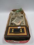 AN OLD TIN MONEY BOX WITH COINS AND BANKNOTES