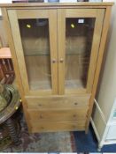 A MODERN OAK EFFECT GLAZED CABINET WITH DRAWERS