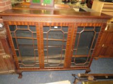 A 20TH CENTURY MAHOGANY GLAZED THREE DOOR BOOKCASE ON BALL AND CLAW FEET 126 X 145 CM