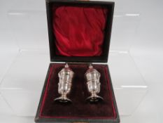 A BOXED SILVER HALLMARKED SALT & PEPPER SET