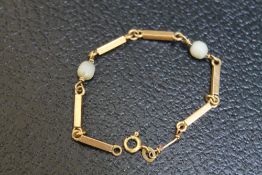 A SMALL CHILD'S GOLD BRACELET, stamped 750 and having two pearl separators - both damaged, approx