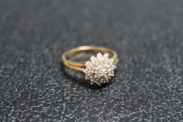 A HALLMARKED 9 CARAT GOLD DIAMOND CLUSTER RING, set with an estimated quarter carat of diamonds,