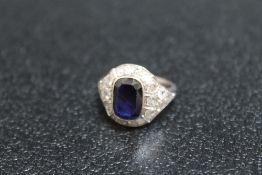 AN ART DECO STYLE SAPPHIRE AND DIAMOND RING, having an emerald cut style sapphire measuring approx